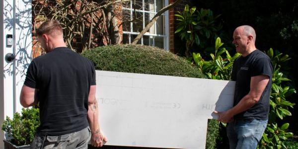 Two Henderstone team members carrying a slab of stone