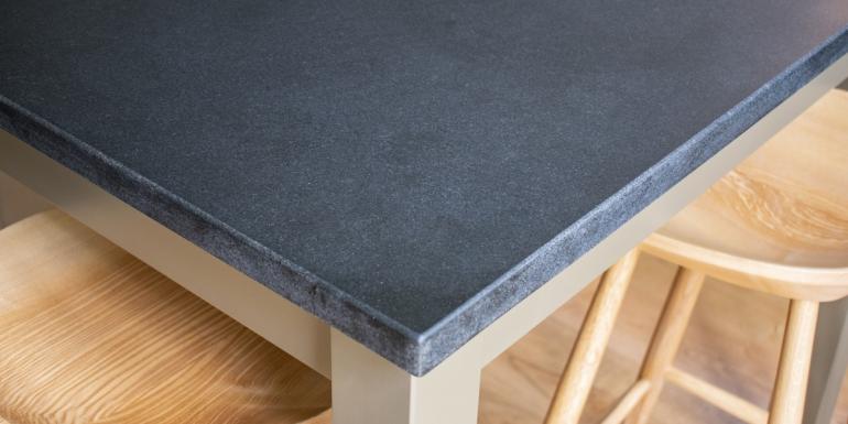 honed black granite kitchen worktop corner with wooden stools underneath
